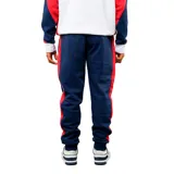 Pantalon de jogging azul marino con franjas laterales en rojo y blanco. Presenta el escudo del Club Nacional de Football en el muslo derecho y el logo de Umbro en el izquierdo. Cuenta con cintura elástica con cordón ajustable y puños en los tobillos.