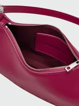 Bolso de hombro pequeño de cuero blanco, con forma curva y correa de cadena plateada. Incluye un dije colgante de estrella plateada.