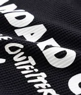 Remera de manga larga confeccionada en tejido de algodón con textura tipo waffle. Presenta un diseño de calce regular con estampado tipográfico en la espalda y cuello redondo.