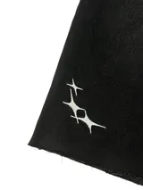 Bermuda de jean negra, corte ancho, largo a la rodilla y detalle de estrellas blancas en la pierna izquierda.