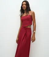 Pollera midi de estilo sastrero color bordó, con cintura estructurada, trabillas y lazo frontal en cordón del mismo tono. Presenta un corte recto y fluido.