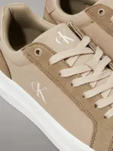 Zapatillas urbanas Calvin Klein confeccionadas en lona de algodón reciclado color beige, con detalles en gamuza y cuero al tono. Presentan suela gruesa de goma blanca y el logo CK bordado en el lateral.