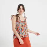 Blusa negra con estampado de flores celestes y hojas verdes, con breteles finos con volados.