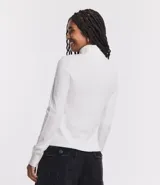 Polera de punto de manga larga con cuello alto, confeccionada en una mezcla de viscosa, poliéster y nylon. Presenta puños y ruedo acanalados.
