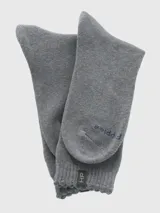 Calcetín de largo medio en color gris melange, confeccionado en tejido grueso con puño suave y detalle de etiqueta con logo en la parte superior.