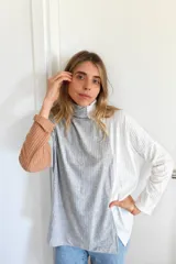 Polerón de cuello alto con diseño tricolor en bloques, confeccionado en tejido de punto acanalado. Presenta una manga en color tostado, el cuerpo central en gris y la otra manga junto con el lateral en color blanco.