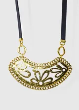 Collar con dije de flores caladas color dorado, con cadena de eslabones y tira de cuerina negra.