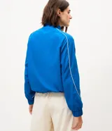 Campera deportiva Get Over de microfibra color azul, con diseño oversized, gola alta, cierre frontal y detalles de líneas en contraste. Cuenta con bolsillos frontales, puños elastizados y dobladillo con cordón ajustable.