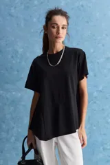 Remera negra de manga corta, con cuello redondo y diseño asimétrico de corte evasé con costuras diagonales.