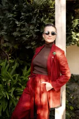 Pantalón de pierna recta con estampado de cuadros en tonos rojo y negro. Presenta cintura alta con lazo ajustable, elástico en la parte posterior de la pretina y cierre lateral.