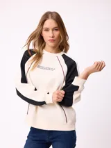 Buzo de cuello redondo con diseño color block, cuerpo en tono crema y mangas negras con detalles de costuras en color bordó. Presenta logo de la marca estampado en el centro del pecho y corte holgado.