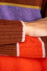 Sweater color crema con rayas horizontales en tonos rosa, marrón y verde.