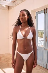 Top de bikini triangular color negro con copas removibles y tiras finas para atar al cuello y la espalda.