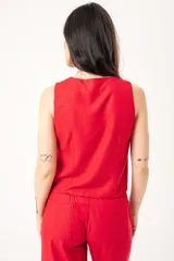Chaleco rojo con escote en V, sin mangas y cierre frontal con botones. Confeccionado en lino imperial con lurex.