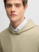 Canguro color beige con capucha y bolsillo tipo canguro.