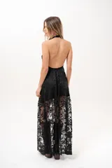 Vestido largo negro de encaje con cuello halter y espalda descubierta, con forro corto y falda translúcida.