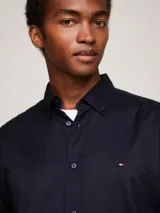 Camisa azul marino de popelina flexible de algodón orgánico, con cuello abotonado, mangas largas y logo de Tommy Hilfiger bordado en el pecho.