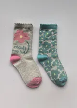 Pack de dos pares de medias de media caña con diseño floral. Un par es gris jaspeado con una flor rosa grande y detalles en rosa en talón y puntera. El otro par es gris jaspeado con estampado de flores turquesas y detalles en turquesa en el borde superior, talón y puntera.