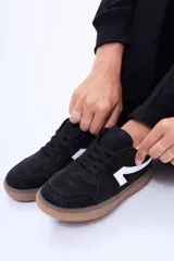 Championes urbanos de diseño minimalista, color blanco con detalles en verde oliva en los laterales y suela de goma color caramelo.