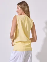 Blusa amarilla sin mangas de lino y rayón, con cuello a la base y escote en V, abertura central con botones y terminación anudada.