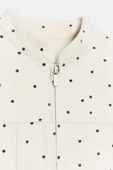 Chaqueta entallada de cuello redondo y manga larga, con cierre frontal de cremallera y falsos bolsillos de solapa en el delantero. Presenta un diseño estampado de lunares.