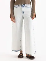 Jeans wide leg cropped de denim color blanco suave con efecto de lavado ácido (bleach wash). Presenta tiro medio y diseño de pernera ancha.