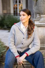 Cárdigan de punto gris con cuello camisero y detalles en rojo en cuello y puños. Cierre frontal con botones.