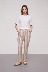Pantalón babucha celeste con rayas verticales blancas, cintura elástica con cordón y detalle de borlas.
