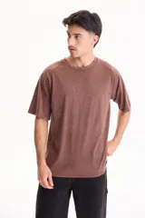 Remera oversize de manga corta raglán, color marrón con efecto acid wash, corte semi boxy y cuello redondo.