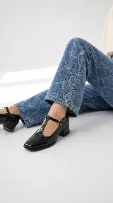 Zapatos de charol negro tipo Mary Jane con diseño T-bar, punta cuadrada y taco bajo ancho.