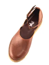 Zapato plano tipo bailarina o mary jane, color gris claro, con puntera redonda y tira de ajuste con hebilla en el tobillo. Suela negra.