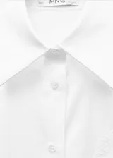 Camisa de corte oversize confeccionada en tejido popelín de mezcla de algodón y lyocell. Presenta diseño recto, cuello camisero, cierre frontal con botones y manga larga con puños abotonados. Incluye un sutil detalle bordado en el pecho.