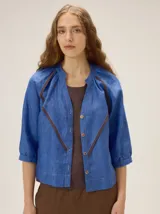 Camisa azul de lino con mangas 3/4, cuello redondo y detalles de ribetes en contraste.