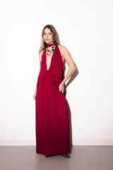 Vestido largo bordó con escote halter pronunciado, detalle de nudo en el centro y tajo lateral en la falda.