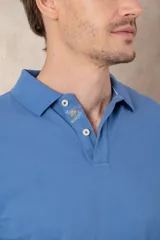 Chomba azul de piqué de algodón con cuello polo, tapeta de dos botones con diseño estampado en el interior y mangas cortas. Corte clásico.