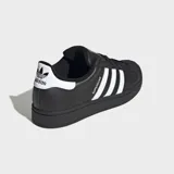 Championes Adidas Superstar II de diseño clásico, color negro con las icónicas tres bandas laterales en blanco. Presentan puntera de goma reforzada, suela de goma al tono y detalle de logo en el talón.