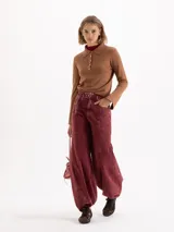 Sweater de punto color rosa, con cuello polo, cierre frontal con botones y mangas largas con puños acampanados.