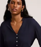 Camisa azul marino de viscosa con cuello mao, cierre frontal con botones y mangas largas con puños elásticos.