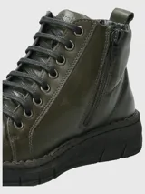Botín de cuero color verde militar con cordones negros y suela de poliuretano.