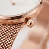 Reloj analógico de mujer con caja redonda de metal color oro rosa y malla de acero tipo milanesa. Presenta una esfera minimalista con índices simples y movimiento de cuarzo japonés.
