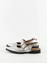 Chatitas plateadas de cuero con punta fina, tira sobre el empeine con hebilla y talón descubierto.