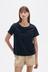 Blusa de viscosa color natural, con cuello a la base, manga corta y detalle de plisado cruzado en el frente. Presenta un corte holgado.