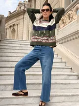 Sweater de tejido de punto artesanal en color verde oliva, con diseño de guardas geométricas y motivos botánicos bordados en tonos blanco, azul y rojo. Presenta cuello redondo, mangas largas y terminaciones en tejido acanalado.