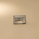 Anillo de plata 925 con acabado satinado, caracterizado por un diseño geométrico de líneas horizontales paralelas que forman una estructura rectangular abierta.