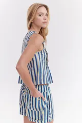 Blusa blanca sin mangas de algodón, con diseño de tablas frontales y escote con lazos para atar.