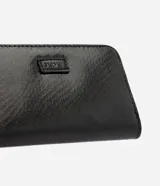 Billetera pequeña marca Satinato, color negro, confeccionada en PU con textura. Cuenta con cierre perimetral, divisiones internas y correa lateral de mano.