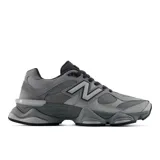 Championes urbanos New Balance modelo 9060, color gris con detalles en tonos más oscuros. Presentan un diseño robusto con entresuela esculpida, combinación de malla y cuero en la parte superior, y el logo 'N' característico en los laterales.