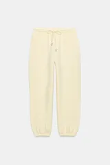 Pantalón jogger de tiro alto color amarillo pastel, con cintura elástica ajustable mediante cordones y puños elásticos en los tobillos.