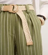 Short de viscosa y lino color verde con rayas verticales blancas, de tiro alto y calce holgado. Incluye un cinturón de ráfia trenzado en color beige y cuenta con bolsillos laterales.