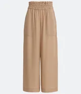 Pantalón pantacourt color beige, con cintura elástica y bolsillos cuadrados aplicados.